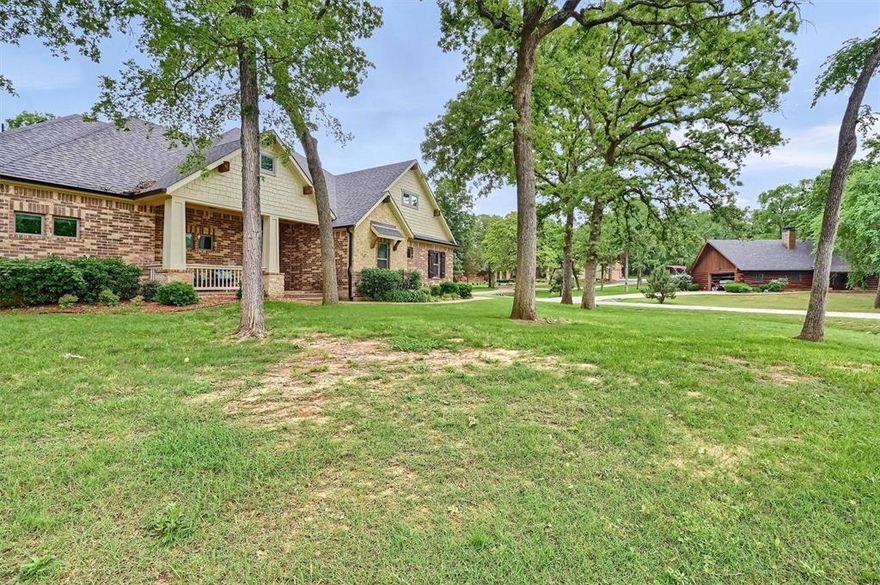 This stunning custom built home sits on one of the most beautiful interior corner lots in Lake, Kiowa. You’re invited up to the house with an adorable covered front porch. The exterior of the home features a spread of beautiful trees, brick, stone, and tons of cedar wood accents. Some of the freshly painted interior features that include crown molding, engineered hardwood floors, 10 & 12 foot ceilings, gas log fireplace, rounded corners, tall baseboards, and so much more. The open island kitchen features granite counters, a breakfast bar, gas cooktop, & double ovens. Spacious master has dual vanities, a garden tub, walk-in shower, & huge walk-in closet. Other bedrooms are of generous size & plenty of closet space. The screened in back porch has wood & brick accents that is one of a kind. To top it off, the oversized 4 car garage has plenty of room for your toys & is also fully decked above with a staircase for easy access to storage. Under the staircase is a steel reinforced storm shelter. A new roof and gutters were installed last year. This one has it all!