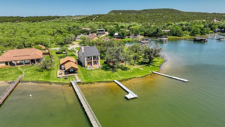 Motivated Seller! Experience lakefront living on the Peninsula at Possum Kingdom Lake! This 4-bedroom, 3-bathroom property offers a thoughtfully designed layout with minimal upkeep, perfect for maximizing your time at the lake. The easy-to-maintain lot features a gentle 40-foot slope from the patio to the water, providing seamless access to lake activities. Approved by the BRA for a 32x34 sq. ft. dock, this property is ideal for boating, fishing, and enjoying the tranquil waters. Whether relaxing on the patio or stepping into your next water adventure, this home delivers the ultimate lakeside retreat. Don't miss this unique opportunity!