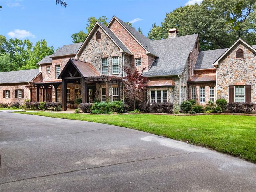 Welcome to an extraordinary residence nestled on nearly 3 wooded acres in one of Tyler’s most exclusive enclaves. With a spring-fed stream, towering trees, and curated outdoor living spaces, this home offers a rare blend of natural serenity and refined sophistication.

Inside, a sprawling living room flows seamlessly into the gourmet kitchen—an entertainer’s dream—while walls of windows frame peaceful views of the surrounding landscape. The main-level primary suite is a true retreat, boasting his and hers spa-inspired bathrooms and dual walk-in closets for unmatched comfort and privacy.

Upstairs, you’ll find spacious guest bedrooms, two with their own ensuite baths, along with a large game and media room perfect for movie nights or family fun.

Work from home in the custom office or step outside to your own outdoor sanctuary—complete with a covered porch, built-in BBQ, and a wood-burning fireplace ideal for cozy evenings under the stars.

The home’s private courtyard, expansive layout, and unmatched natural beauty make this estate one of Tyler’s finest offerings.