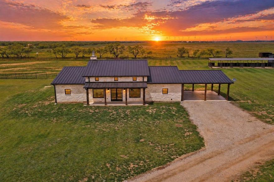 Welcome to a rare turn-key ranch that perfectly blends luxury living with a fully functional horse and livestock setup. The land features pipe and cross fencing, creating multiple turnout paddocks ideal for rotational grazing. Equestrian improvements include a shed row barn with multiple covered stalls and runs, loafing sheds, and a set of working pens. A dedicated riding arena and round pen provide excellent space for training and riding, and a reliable stock tank. The main residence showcases a high end finish out with a modern ranch aesthetic. Inside, there is soaring vaulted ceilings with exposed wood beams, a striking floor to ceiling stone fireplace, expansive windows and glass doors. The kitchen is a showpiece, featuring custom cabinetry, quartz countertops, high end appliances, a large island with seating, and designer lighting, all opening to the main living area, perfect for entertaining. The primary suite is a true retreat, offering a spa like bathroom with a freestanding soaking tub, oversized walk in shower, dual vanities, and luxury finishes throughout. Step outside to a covered back patio overlooking the ranch, creating the perfect place to unwind and take in the peaceful setting. At the front of the property sits a secondary residence, offering incredible flexibility and value. This 1,753 sqft, 3 bed, 2 bath barndominium on its own dedicated 1 acre parcel and features a finish out that rivals the main home. Inside, you’ll find an open-concept layout with beautiful finishes, a spacious kitchen, and a large laundry room and oversized pantry. The home also includes a separate large shop, providing excellent space for equipment, hobbies, or business use. With its combination of a luxury main home, income-producing or multi-generational guest property, and a fully equipped equine facility, this property offers a rare opportunity to own a true lifestyle ranch. Functional, beautiful, and ready to go—this is country living at its finest.
