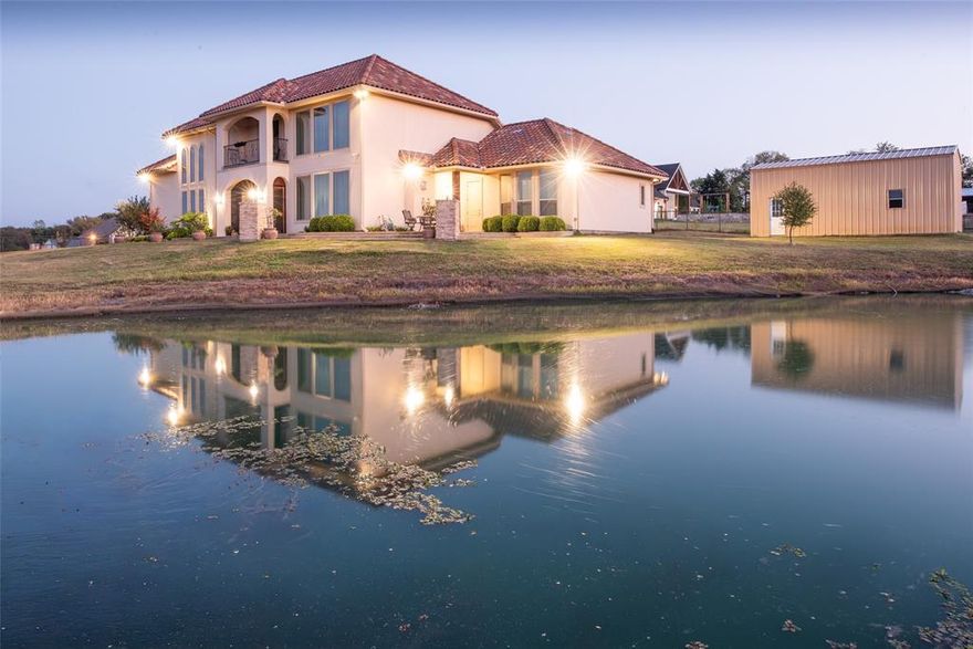 Stunning Custom Mediterranean Estate on 2 Acres with Lake Views. Experience luxury and craftsmanship in this custom-designed home by award-winning builder Homes by J. Anthony, completed in 2018. Nestled on 2 acres with scenic lake views and just a short walk to Lavon Lake, this residence seamlessly combines elegance, functionality, and outdoor living. Featuring 3 bedrooms, 3 full bathrooms, and 2 half bathrooms, the home offers abundant space with a media room, home office, additional study area, formal dining, living room, and a versatile game area. High ceilings, wood plantation shutters, generous counter space, and ample cabinetry enhance the interior’s comfort and style. Step outside to a screened patio with built-in grill, a balcony, and enjoy the beautifully maintained 6-foot-deep pond with aerator and liner (2024). The property also includes a 15 ft x 30 ft barn, solar-powered automatic entry gate, and iron fencing (2021) — perfect for hobbies, storage, or entertaining. The Mediterranean-style exteriors with stucco walls and tile roofs provide exceptional durability, energy efficiency, and lower insurance costs, while the expansive lot offers complete privacy with no HOA restrictions. This home is ideal for those seeking a combination of luxurious indoor living, functional outdoor spaces, and a tranquil lakeside lifestyle.