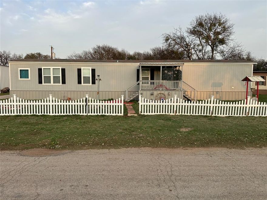 Beautiful 2021 single wide mobile home in excellent condition located at 4151 Iroquois Dr in the Thunderbird Bay community near Lake Brownwood, Texas. Sitting on two lots totaling approximately 0.23 acres, this well maintained property offers comfortable living with several outdoor improvements.

The home features three bedrooms and two bathrooms with a split bedroom layout. The primary bedroom includes a walk in closet and private bathroom with soaking tub, step in shower, and double vanity. The hall bathroom has a tub and shower combination.

The kitchen has a modern farmhouse feel with attractive wood tone cabinets, a center island, and a stainless farmhouse style sink with pull down sprayer. Appliances include an electric range, exhaust hood, dishwasher, and Whirlpool side by side refrigerator with bottom freezer drawer.

The living room includes decorative ceiling beams and a ceiling fan. Faux 2 inch wood style blinds are installed throughout the home. Electric central heat and air provide year round comfort.

Outdoor living is another highlight. A covered front deck faces west and is perfect for enjoying sunsets. The larger covered back deck faces east and is ideal for morning coffee and sunrises.

Additional improvements include a large covered patio or carport, a hobby or workshop building with electricity and window air conditioner, and a metal garage with concrete floor and electricity.

A tall fenced garden area helps protect plants from deer and other wildlife common in the neighborhood.

Located within the Thunderbird Bay HOA, the home is within walking distance of the neighborhood pool and park. Residents also enjoy access to a private boat launch ramp providing convenient access to Lake Brownwood.

This property would make a great full time home, weekend lake getaway, or investment property near Lake Brownwood.