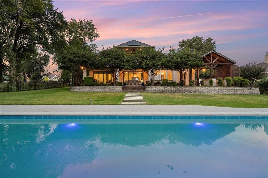 Welcome to 1140 The Shores, a stunning lakefront retreat on Richland Chambers Lake where every day feels like a dream. Just over an hour from Dallas and three hours from Houston, this four-bedroom home offers luxury, energy efficiency, and resort-style amenities in one of the lake’s premier gated communities.
Designed for seamless indoor-outdoor living, the open-concept living area includes a fireplace, a light-filled dining room, and a gourmet kitchen with KitchenAid appliances, quartz countertops, a large island, custom cabinetry, and a walk-in pantry. Expanded sliding glass doors frame open water views and lead to a covered patio, a fully-equipped outdoor kitchen, a 60-ft pool with a heating-cooling pump and auto cover, and the boathouse with lift. Enjoy swimming, grilling, boating, fishing, or relaxing by the shoreline, secured by a new 14-ft steel seawall.
The primary suite offers lake views, patio access, a soaking tub, a separate shower, and two custom walk-in closets. A private office, a full bath with patio access, and an oversized laundry room with space for a fridge and freezer complete the 1st floor. Upstairs are three bedrooms and a game room with a dry bar that opens to a balcony with incredible views. Two walk-in attics offer storage and room to add-on.
Fully owned solar panels and a Tesla Powerwall dramatically improve efficiency, keeping the avg monthly electric bill low. Additional highlights include mature landscaping, backyard fencing, custom window shades, and a 3-car garage with built-ins. The Shores offers a clubhouse, fitness center, community pool, marina, and boat ramp. The home is zoned for top-rated Mildred ISD, making it a great choice for families who want to experience lake living full-time.
Whether you are looking for a full-time home or a weekend escape, this Texas lake house offers luxury, comfort, energy efficiency, and unforgettable sunsets over Richland Chambers Lake.