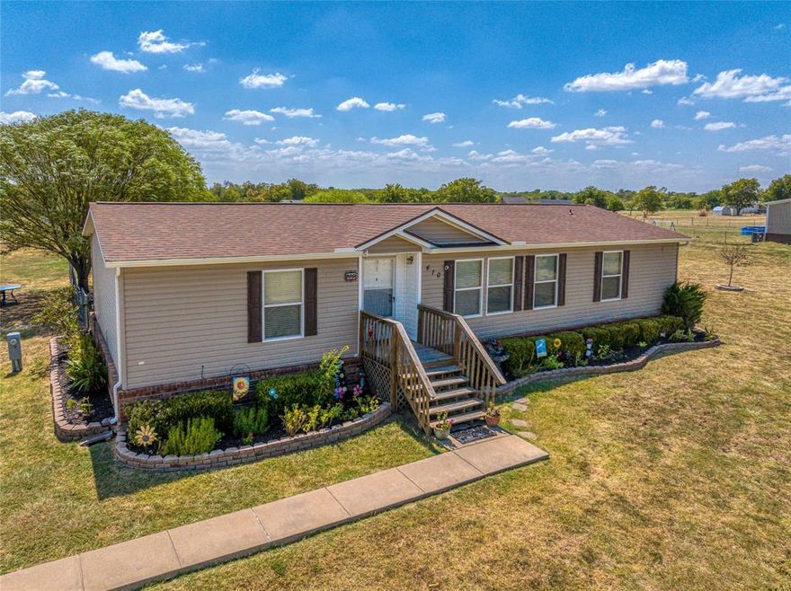 A well kept home with a larger neighborhood lot of 1.24 acres. 3 flower gardens, several trees that include 3 kinds of fruit trees, a 3 year old pecan tree, and an enhanced soil vegetable garden space. Exterior brick skirting, with vinyl siding brings great curb appeal. Spacious deck with a country view. 2 car covered parking. New roof June of 2023. Plenty of space to cook in the kitchen with a large island. Interior open space layout featuring hardwood laminate flooring and a garden tub. A storage shed and an unattached insulated, air-conditioned shop with electric hook ups for the hobbyist. Southmayd is an easy drive surrounded by rolling hills, and lush pastures, a charming town with a small population for someone looking to move away from the hustle and bustle. Within 30 minutes of Lake Texoma or Hagerman wildlife reserve, and within 20 minutes of downtown Sherman. This house is the trifecta of location, affordability, and all-around great living. Come take a look today.