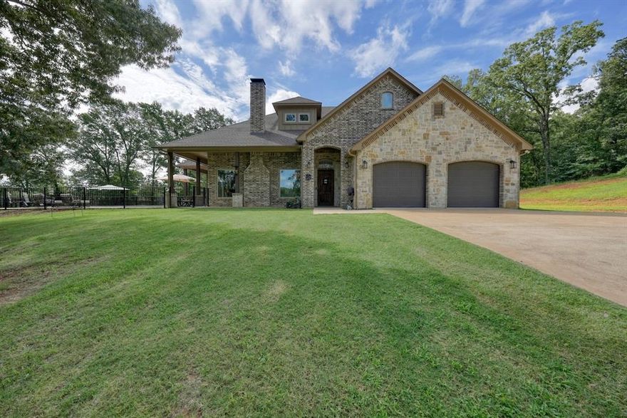 Looking for a private retreat with breathtaking water views? This stunning 4-bedroom, 3-bath, 4-car garage home offers nearly 2,900 sq ft on almost 7 peaceful acres in Lindale, Texas. The interior has been extensively updated with new lighting, ceiling fans, outlets, switches, blinds (including remotes in the family room), fresh paint, and modern hardware. The kitchen and baths feature new countertops, sinks, faucets, mirrors, backsplash, and appliances including a gas cooktop. A redesigned bath layout, new toilets, heated towel bars, and a lighted mirror add style and convenience. The split floor plan provides privacy, with a luxurious primary suite boasting dual vanities, LED-lit walk-in shower, and a large closet. Expansive picture windows frame views of the stocked lake, home to Florida Bass, Bluegill, and Crappie. Outdoor living shines with epoxied porches, a pool, fire pit, pier, and a tornado shelter. Added features include a remote-start fireplace, stereo system, Jellyfish lighting, mini-splits in both garages, new openers, wall-mounted hose reels, added driveway access, and generator-ready service. The property benefits from a wildlife exemption, with taxes only assessed on the 1 acre where the home sits rather than the entire 7 acres. The exemption renews annually pending Smith County approval, offering significant long-term savings. This property blends modern updates with natural serenity. Schedule your private showing today—this is one you don’t want to miss!