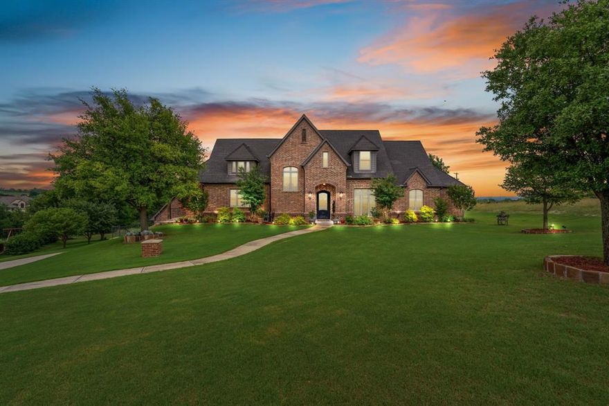 Perched atop a scenic hill in the gated community of Bella Flora - Bella Ranch, this exceptional property spans 2.87 acres and captures sweeping skyline views of Fort Worth. Thoughtfully designed for both everyday living and effortless entertaining, the home offers 3,722 square feet of beautifully appointed space, including 4 bedrooms and 4 full bathrooms. The main level features a serene primary suite, a private guest bedroom, a dedicated home office, and both formal and casual dining areas. The formal dining opens to the living room and includes a stylish wet bar. At the heart of the home, the kitchen impresses with a large center island with prep sink, double ovens, and generous storage. Upstairs, you'll find two spacious ensuite bedrooms and a second living area—ideal for a game room, media lounge, or teen retreat. Step outside to enjoy wide-open green space, a covered patio with a built-in grill, and a full sports court equipped for basketball, tennis and volleyball —complete with a rebounding net and lights for nighttime play. There’s plenty of room to add a custom pool, and with ACC approval, the lot also allows for a guest house or workshop. Additional highlights include hand-scraped hardwood floors, a 4-car garage, and a side-entry porch with direct access to the kitchen—perfect for everyday convenience. Well: new pump in 2019, new control box in 2020. This is Texas living at its finest - luxury, land, and lifestyle, just minutes from Fort Worth’s top-rated private schools, premier shopping, dining, and with convenient access to the property off 377. Foundation: Engineered post tension and pier.