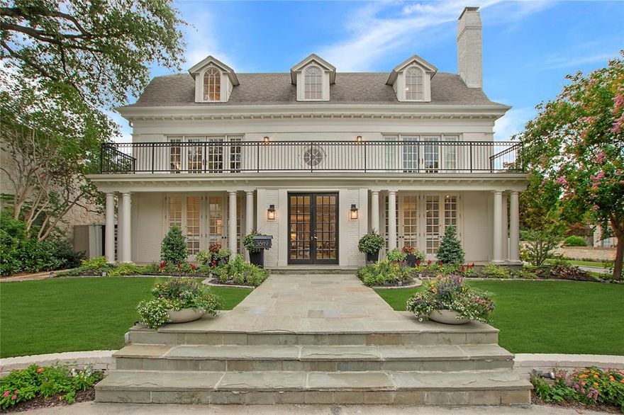 Commanding attention on its gorgeous 66’ x 150’ corner lot in prestigious University Park near Centennial Park, Curtis Park, University Park Pool, and the Volk Estates, this custom-built classic traditional home masterfully blends timeless architecture with refined transitional style and has been previously featured in Architectural Digest. The stately three-story brick home, with its Gambrel roof and surrounded by manicured landscaping and blooming crepe myrtles-offers a seamless blend of classic charm and elevated, transitional style-delivering effortless luxury from the very first glance. 
Step inside to soaring 10-ft. ceilings, rich hardwoods and an expansive central hall that anchors elegant entertaining spaces and intimate retreats. The formal living room, with its limestone fireplace and French doors, opens to a private outdoor oasis. Both with light-filled French doors opening to the outdoors, a formal dining room leads to a scenic side patio and a richly appointed library opens to a front porch-adding to the home’s dignified charm. The chef’s kitchen dazzles with white Carrara marble, a Wolf commercial range, and premium appliances-think SubZero, Thermador, Asko and Hoshizaki-flowing seamlessly into a cozy breakfast nook. With French doors opening to a front porch, the downstairs primary suite is a tranquil escape with its gorgeous spa-like white quartz and porcelain tile bath & custom walk-in closet. Upstairs, an oversized den, sitting room, 4 spacious bedrooms & a private guest suite with its own bath & adjacent kitchen offer space & flexibility. The 3rd floor reveals a game room, mirrored gym or playroom & a full bath-easily convertible to a 7th bedroom. Outside, a serene pool & spa-complete with soothing fountains, color-changing LED lights & surrounded by turf grass & honed limestone-invite relaxation & entertainment year-round. A 2-car garage with sliding gate completes this rare offering-an effortlessly elegant home in the heart of University Park.