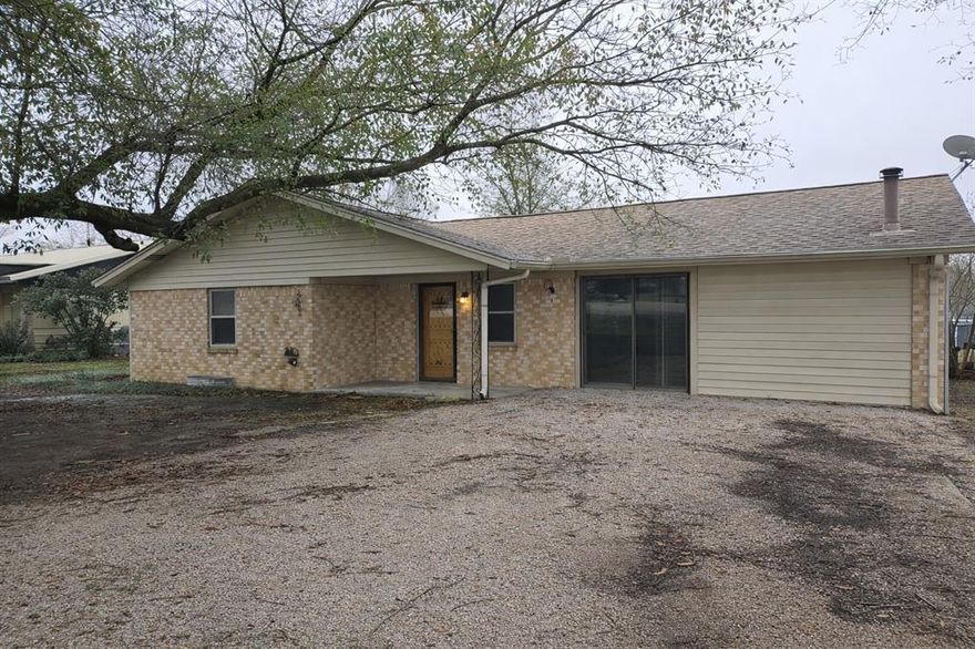 Brick home with top-grade aluminum siding located outside city limits and conveniently near major Limestone County employers, including the Mexia State Supported Living Center.  This home functions best as a two-bedroom layout, with the primary bedroom opened to an adjacent room - ideal for a larger suite, office or nursery  Both rooms include closets, and the primary bath features an updated tile shower.  

Recent improvements include new triple-pane windows and kitchen appliances.  A converted garage provides a comfortable family room with a wood-burning stove, opening to an additional living or dining room.  

The kitchen includes a breakfast area overlooking a fenced backyard with mature greenery and a greenhouse with electricity, offering great potential for gardening.  Priced at $183,500, this home is a solid option for a first-time buyer or someone looking for a short commute.