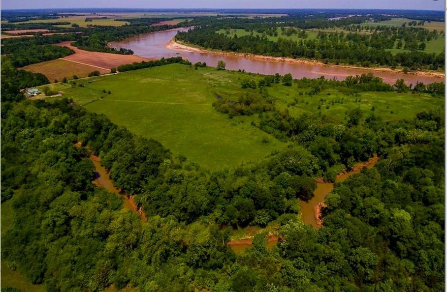 RED RIVER FRONTAGE.  A Very Rare Opportunity to Own 75 + or - acres on the banks of Red River in Lamar County. Over 2500 feet of RIVER FRONTAGE!!  Complete seclusion and an off the grid opportunity.  Fantastic recreational property and a true hunting and fishing paradise. Charming Farmhouse Cottage with lots of natural light and an open floorplan.  Kitchen features include Silestone countertops, water conditioning system, gas range and a pantry. The Primary Bedroom has an eastern facing window with amazing sunrises. Woodstock Soapstone wood stove, and a storm shelter.  Vaulted living room ceiling with 12 ft ceilings in the main areas.  Central HVAC, and County water.  Don't miss an opportunity to own a unique property on the banks of the river.