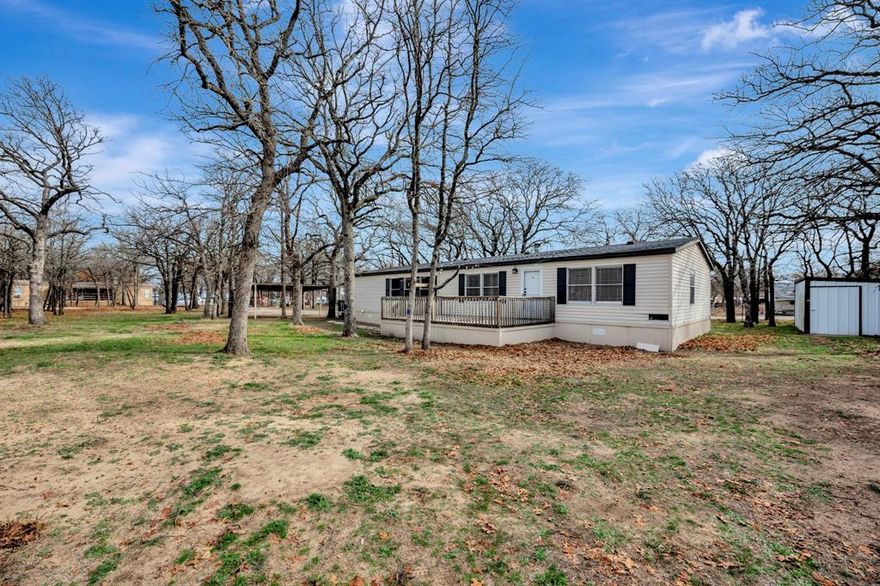 Escape to peaceful country living on 4 beautiful acres in Boyd, Texas. This charming double wide manufactured home offers the perfect blend of comfort and functionality with wide open views, all behind gated access for added privacy. Inside, you will love the warm and inviting living area featuring a cozy wood burning fireplace and durable laminate flooring throughout. The kitchen is designed to impress with stainless steel appliances, a convenient breakfast bar, decorative open shelving, and a stunning view overlooking your expansive property. The spacious primary suite is a true retreat, complete with dual vanities, a relaxing garden tub, a separate shower, and an oversized walk in closet. Outside, the property continues to shine with two spacious decks perfect for entertaining or relaxing, a built in firepit for cozy evenings, and a chicken coop ready for your homestead dreams. There is plenty of room to park an RV, along with a 2 car carport for everyday convenience. The home is serviced by a private well and septic system. With room to roam and thoughtful outdoor features already in place, this property offers the ideal setup for comfortable country living with space to grow.