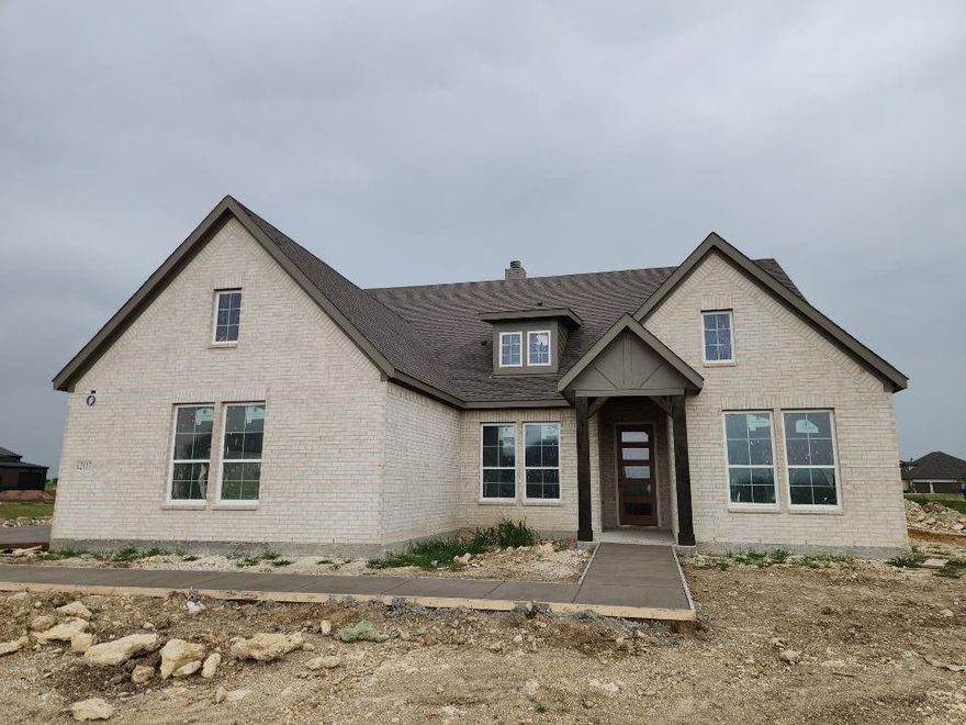 Estimated May 2026 completion! Ask us about our Trade In Trade Up program, we can buy your home! The Verbena floor plan features a modern, open-concept layout and the sought-after features today’s homeowners are searching for. With four bedrooms, three bathrooms, and a flex room, this plan boasts just over 2,400 square feet of functional living space. Upon entering the home off the front porch, you’re welcomed by an inviting foyer. Immediately to the left is a hallway with a bedroom, walk-in closet and full bathroom, as well as a linen closet. Across the foyer is a flex room, perfect for a home office, formal dining room or whatever need your family has for the space. Past the foyer is the family entry, with storage space and mud bench, which leads to the laundry room and two or three car attached garage. Through the entrance, the home opens up to a large family room with a stately fireplace. Adjacent to the family room is a gourmet kitchen, equipped with a walk-in pantry, ample counter space and an oversized island. Finishing off this open-concept living area is a dining space which overlooks the covered back patio. The remainder of this one-story floor plan is just off the living space. A hall leads to two bedrooms with walk-in closets, another linen closet and a shared full bathroom. The back corner of the home offers privacy for the owner’s suite, featuring a massive walk-in closet and bathroom with a dual-sink vanity, standalone soaking tub and glass-enclosed shower.