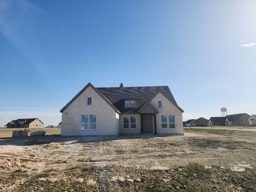 Estimated May 2026 completion! Ask us about our Trade In Trade Up program, we can buy your home! The Verbena floor plan features a modern, open-concept layout and the sought-after features today’s homeowners are searching for. With four bedrooms, three bathrooms, and a flex room, this plan boasts just over 2,400 square feet of functional living space. Upon entering the home off the front porch, you’re welcomed by an inviting foyer. Immediately to the left is a hallway with a bedroom, walk-in closet and full bathroom, as well as a linen closet. Across the foyer is a flex room, perfect for a home office, formal dining room or whatever need your family has for the space. Past the foyer is the family entry, with storage space and mud bench, which leads to the laundry room and two or three car attached garage. Through the entrance, the home opens up to a large family room with a stately fireplace. Adjacent to the family room is a gourmet kitchen, equipped with a walk-in pantry, ample counter space and an oversized island. Finishing off this open-concept living area is a dining space which overlooks the covered back patio. The remainder of this one-story floor plan is just off the living space. A hall leads to two bedrooms with walk-in closets, another linen closet and a shared full bathroom. The back corner of the home offers privacy for the owner’s suite, featuring a massive walk-in closet and bathroom with a dual-sink vanity, standalone soaking tub and glass-enclosed shower.