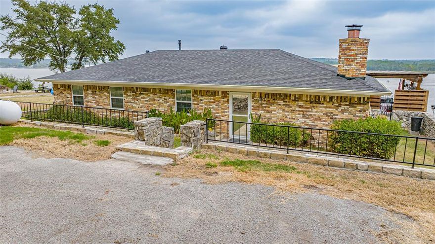 VIEW, VIEW, VIEW - This is the perfect place to kick back and enjoy the Lake. The open living, dining, kitchen area are accented by a wall of windows along back for a spectacular view of Lake Granbury. The stone fireplace, rustic tile flooring and oversize custom Oak top island for dining set the tone for the living area. The backyard is perfect for entertaining with a covered patio, pergola, & hot tub all overlooking the lake. Electric tram down to the covered boat with lift. Located in a private, gated community only minutes from town, restaurants and shopping.