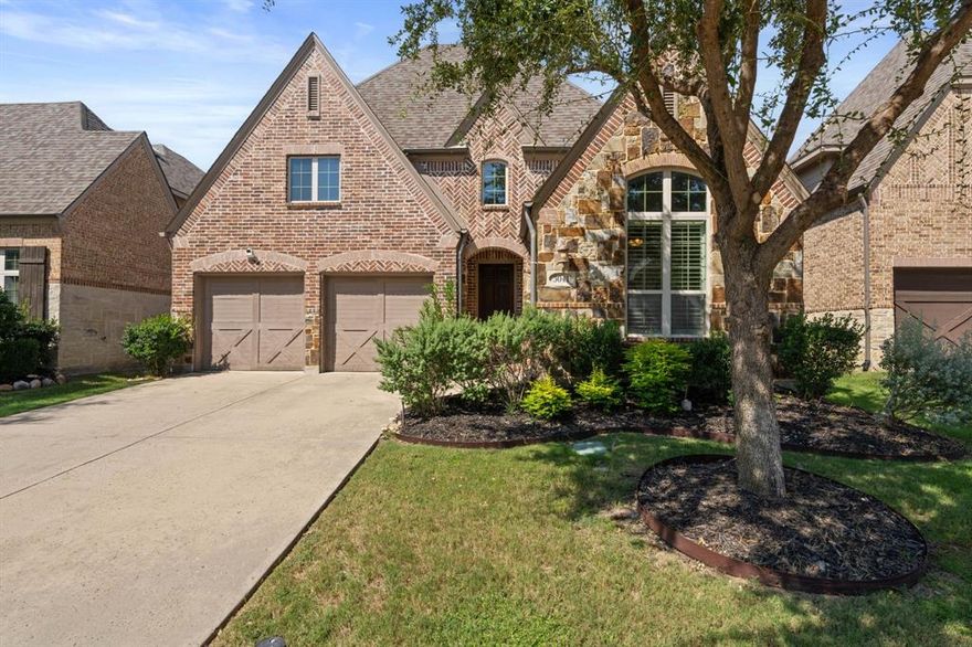 Welcome to resort-style living in The Tribute, a premier master-planned community nestled along the shores of Lake Lewisville. This sought-after neighborhood offers two award-winning golf courses, over 10 miles of scenic nature trails, and a park and marina opening Summer 2026—perfect for boat lovers and outdoor enthusiasts.This beautifully designed 1.5-story home features 4 bedrooms, 3.5 baths, and an expansive upstairs flex room, ideal for a media room, game room, or private retreat. Step inside to find a gourmet kitchen with a large island, hand-scraped hardwood floors, and seamless open-concept living. The primary suite is a true haven with a spa-like bath featuring dual vanities, a garden tub, oversized shower, and a generous walk-in closet. The backyard retreat is built for entertaining and relaxation with low-maintenance turf, a covered patio, and a cozy outdoor fireplace. Community amenities include multiple resort style pools, playgrounds, pickleball courts, a dog park, kayak launch, greenbelt, and year-round community events create the perfect blend of luxury and connection.