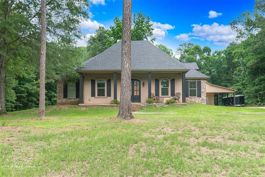 Seller says sell!!!!! GORGEOUS, QUIET & PRIVATE! Acadian style southern home sits on a hill, has wild life come & go. Gorgeous living with built ins around fireplace. Kitchen has large island, granite, stainless steel, tons of storage! Extra concrete for parking, detached shop with carport cover, (inside is 20x30). 2 car garage with 3rd for utility vehicle. Partial lake view of Cypress Lake, lots of trees. Master closet is HUGE! Wood floors in living areas. Open floor plan, exposed brick. Large laundry. New paint in living, kitchen, dining area and upstairs bedroom. New flooring in the living room, dining room and kitchen.