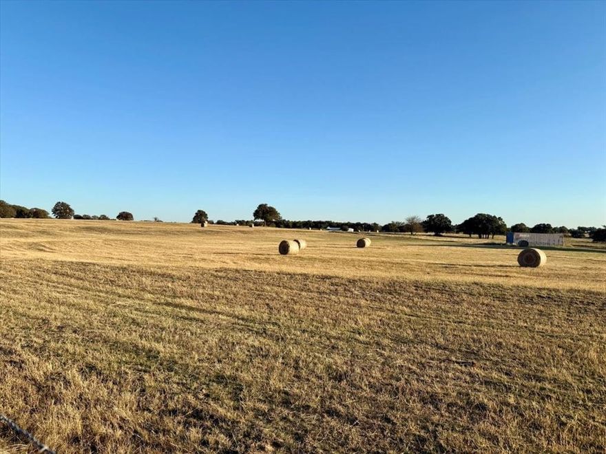 40.5-acre AG-exempt tract with unrestricted use and approximately 600 feet of road frontage. Property is cross-fenced into two pastures and includes two stock tanks. Coastal Bermuda grass averages approximately 80+ bales per cutting over sandy loam soil with scattered mature oak trees. Utilities in place include electricity and septic, supporting immediate development, interim agricultural use, or RV hookup. Suitable for hay production, livestock, equestrian facilities, future homesite development, or land hold investment. Wildlife observed includes deer. Located less than 25 minutes from Weatherford and under one hour to Fort Worth.