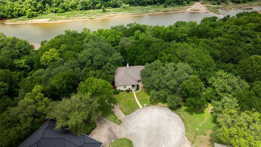 ***RIVER LOT ***Welcome to your Brazos River retreat in the prestigious gated community of Pecan Plantation. This stunning 4-bedroom, 3-bathroom home offers 2,903 square feet of beautifully designed living space, perfectly positioned on a private riverfront lot backing directly to the scenic Brazos River.  Natural light pours throughout the open and airy floorplan, creating a warm and inviting atmosphere. Enjoy seamless indoor-outdoor living with expansive upper and lower patio decks overlooking the peaceful backyard, where deer are frequently seen and direct river access invites endless outdoor adventures including boating, kayaking, paddleboarding, and fishing.
The spacious 3.5-car garage includes additional room for a golf cart and provides convenient access to the community’s renowned 18-hole golf course. Tucked away on a quiet dead-end cul-de-sac, the property offers exceptional privacy along with extra front parking for guests.
An expanded built-in bonus room provides incredible flexibility and can easily function as a workshop, hobby room, man cave, home gym, or additional bedroom. BONUS: Elevator Shaft & Weapon Gun Closet. 
Spanning over 3,000 acres along the Brazos River just below the Lake Granbury Dam, Pecan Plantation offers an unmatched lifestyle with gated security, abundant wildlife, scenic pecan orchards, and a rare blend of luxury, privacy, and convenience. Located approximately 35 miles from Fort Worth, residents enjoy peaceful riverfront living while remaining within easy reach of the Metroplex.
This meticulously updated riverfront home is truly move-in ready and presents a rare opportunity to own a premier property in one of North Texas’ most desirable gated golf course communities. Pecan Plantation is a very unique opportunity to live in.
 
Pecan Plantation features:
Gated community & security
Full Service Club House
Activity Center
Pools
Golf
Tennis
Marina
Airport Runways
Riverside Parks
Access to Lake Granbury
Low HOA Fees