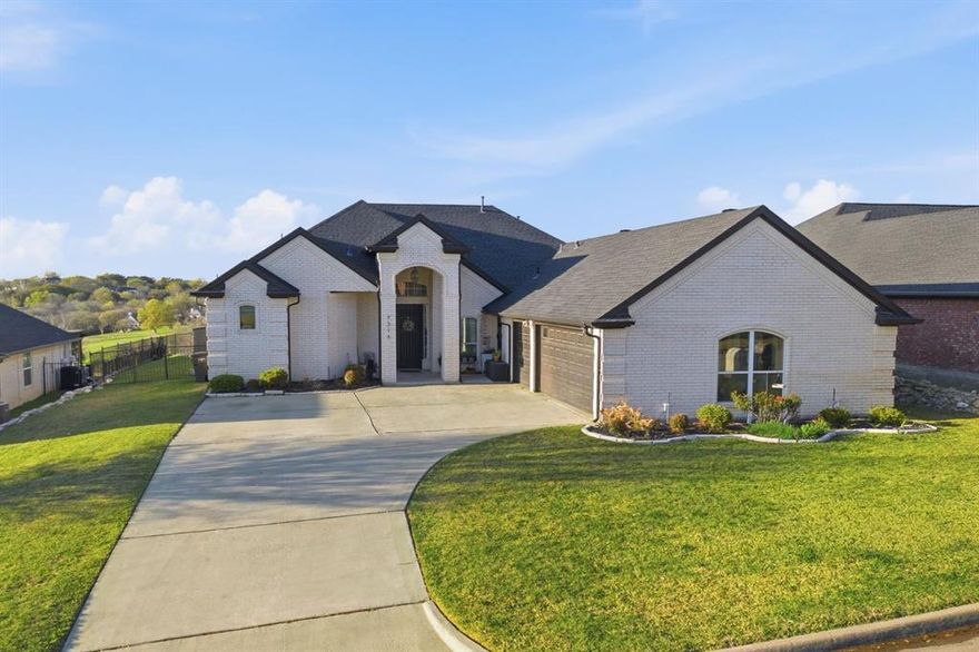 Perched high near Eagle Mountain Lake, this exceptional home offers beautiful hilltop views and unforgettable sunsets. Imagine spending summer evenings swimming in your private pool while watching the sun set across the lake—a rare lifestyle opportunity in this peaceful setting.

This spacious property features 4 bedrooms, 3 full bathrooms, and a fully functional in-law apartment. The garage has been thoughtfully converted into a complete living space that includes a kitchenette, living room, office area, walk-in closet, and full bathroom—perfect for multigenerational living, guests, or private workspace. If desired, the space can easily be converted back into a 3-car garage upon request.

Inside the main home, soaring ceilings and magnificent windows immediately draw your attention to the natural light and beautiful views surrounding the property. The inviting living room features a cozy wood-burning fireplace, creating the perfect space for gathering with family and friends.
The primary suite feels like its own private wing, complete with French doors, generous space to relax, and direct access to the back patio. The home sits on approximately half an acre, offering a massive yard with endless possibilities.
Outside, enjoy a large covered patio overlooking the pool, a garden area, and plenty of open space to play and entertain. As the yard extends further back, you'll find direct access to community trails and a peaceful pond, adding even more outdoor enjoyment right from your backyard. The home is also located on a cul-de-sac, and the expansive front driveway provides plenty of safe space for kids to ride bikes or play.
Conveniently located near Lake Country Christian School, this property combines scenic lake living, space for the whole family, and incredible versatility. Homes with views, land, and a private apartment like this are truly rare—come experience it for yourself.