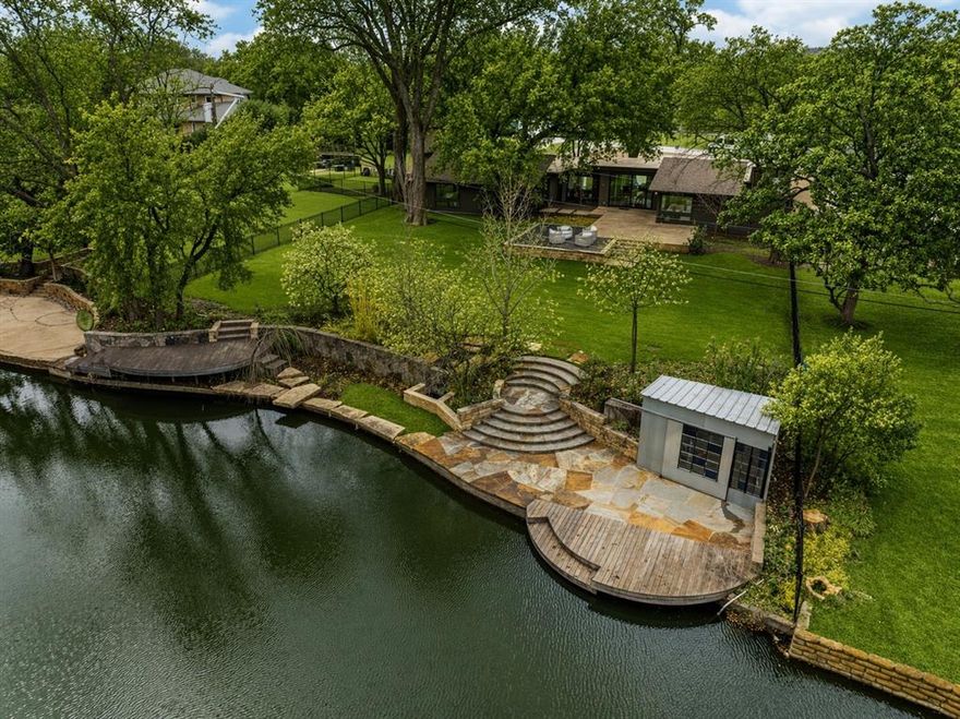 A One of One! Rarity in Preston Hollow. This Re-imagined Mid Century Modern from the 1950s sits upon a private Oversized Lake Lot with a Boat House. You feel like you are on vacation the second you step through the doors. The restoration on this home began in 2025 with designer Debra Stewart and prior installment by Charles D Bobo. The Design improved the functionality of the home while maintaining the homes architectural spirit. In the Kitchen new Clean lined white oak cabinetry was installed, Rare turquoise-toned imported granite counters, New SS Appliances, water filler, backsplash, under-mount lighting and refinished oak floors. Living spaces were opened creating a more expansive and connected environment. A new fireplace clad in Old Chicago Brick flanked by Built in Oak cabinets. Near the entry a custom architectural slat wall feature offers subtle separation while adding rhythm and texture to the interior. Throughout the home electrical systems were modernized, insulation was upgraded with foam insulation, and New Hvac was installed. Primary Bedroom was fully updated to match the quality of the main living spaces w New Hardwood Floors, cabinets, counters, lighting, and plumbing. The front of the home has a separate space for an office or gym with an ensuite full bath. Outside was improved with fresh paint, drainage, and landscaping.  While the lakeside fishing hut offers a charming retreat for casting a line into the fully stocked lake. A garden sink and outdoor shower adds to the properties unique character.  Set within a tranquil lakeside setting. This home offers a rare blend of architectural authenticity and modern livability. From its natural materials to the thoughtful updates, Westmere Circle is a home that respects the past while beautifully embracing the present.