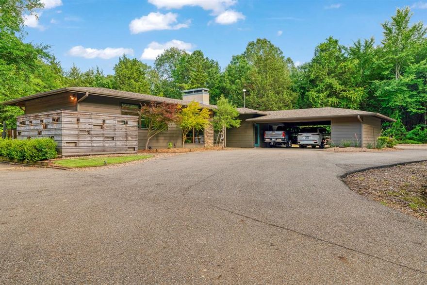 Mid Century Modern lovers take note!  This 3 bedroom 2 bath custom built home located on a quiet county road in the Powderly area is secluded at the end of a long, paved drive and comes with covered storage for your tractor, utility trailer, SxS, etc. all situated around a 20' cone.  In addition, the property has a large, enclosed shop style building perfect or your RV, boat, etc.  This building is replete with a gathering area, bar, kitchen and bath.  Two large ceiling fans and two split AC units cool the massive entertaining area in addition to a large outside seating area with its own fan.  The building is also designed for pull through access boasting 12 ft high and 14 ft wide automatic doors on the front and rear with a gravel drive encircling the house leading to the rear entrance of the building.

Water for dish washing, toilet, shower and outdoor faucet for the shop-storage building is provided via water catchment with water pump, accumulator and filter system.  

The home boasts a gracious inviting entry leading to a large open concept living, dining and kitchen. This area is flooded with copious amounts of sunlight due to the large, insulated, low-E windows replete with shades assisting with the very manageable utility bills. Much care was given in the pre-build of this home in the post tension cable foundation and the envelope foam insulation throughout the house and 40 year composition roofing.  

The main hallway accesses the primary bedroom, two guest bedrooms, a hall bath and a generous utility room.

The back of the home is flanked by a 12' pressure treated deck stretching almost the entire length of the back of the house.  The back yard is surrounded by custom fencing and a separate dog run. The area also contains a covered area for grilling or barbecuing. 

This home is perfect for watching the various wildlife that cross over daily.  Easy access to lakes, groceries, restaurants and home is within 7 miles of Paris.