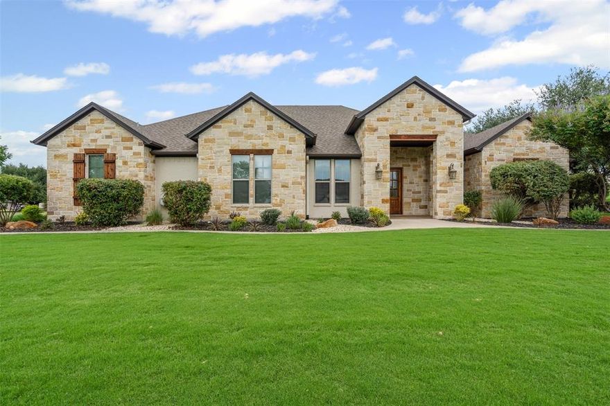 Fantastic Granbury home on 1+ acre corner lot, superbly landscaped with beautiful stone facade. Stylish and durable wood-look tile flooring throughout common areas. Large family room, open to kitchen, with magnificent stone fireplace, gorgeous wood beams and towering ceiling. Kitchen includes ample granite counters, island sink, abundant storage in cabinets & pantry and built-in stainless microwave, double-oven & gas cooktop. Tankless hot water heater & whole house surge protector plus concrete reinforced storm safe room. Spacious main bedroom with sitting area, private backyard access and sumptuous en suite with dual vanities, free-standing tub, frameless glass & tile shower and vast walk-in closet. Backyard features an expansive covered patio with ceiling fans and gas stub for grill. Welcome home!