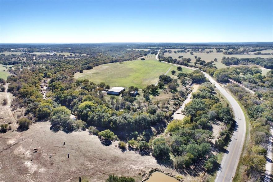 DEVELOPMENT POTENTIAL! Great location, close to a coveted Parker County small town with a great ISD, great people and more! Welcome to this beautiful AG EXEMPT 27 acre piece of unrestricted land WITH WATER in Weatherford, Texas: the Cutting Horse Capital of the World This property is located just across the road from a 20 mile trailway! This property boasts views of an improved coastal hay field skirted with mature hardwoods including Post Oak and Live Oak trees and deep creek. The 5,400 sq ft insulated shop is nested amongst lots of trees, complete with water, electricity, a cabinet shop and wood working equipment which may be included with an acceptable offer. Attached to the shop is another large barn space which is used for equipment but could easily be converted to a horse barn. Check out the cattle pens, including a tub and alley, simplifying working cattle and a large loafing shed providing shelter for all types of livestock. Like to fish? Check out the deep creek on the North side of the property. Even in a hot, dry summer, the creek has plenty of water in it providing a nice water source for livestock.