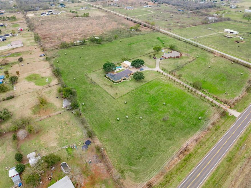 Experience wide open Texas living on 6.11 acres in the peaceful Kaufman area, a community known for its small-town charm, locally owned shops and dining, excellent access to Hwy 175, and an easy commute to Dallas. This 2,920 square foot home blends comfort and character with decorative ceilings, oversize windows, and thoughtful design throughout. The living room features a tall ceiling, gas fireplace, built ins, and beautiful natural light, while the large kitchen offers stainless appliances, abundant wooden cabinetry, and expansive counter space that flows into the dining room. The ensuite primary bedroom includes a corner garden tub, separate shower, and dual vanities, with additional accommodating bedrooms and a dedicated laundry room for stocking up. Outside, enjoy true Texas living with an in-ground pool with waterfall, cabana, and large covered back porch overlooking your pool. Positioned minutes from everyday conveniences and under an hour drive from Dallas, this property delivers peaceful country living with exceptional accessibility. Proudly Claim Your Piece of Texas!