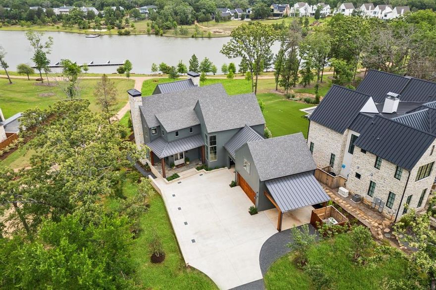 Tucked beneath a canopy of trees on a premium oversized lakefront lot in Long Cove, 13160 Woodsy Way blends luxury, comfort, and privacy in a beautifully designed retreat. With over 4800 square feet, plus additional bonus space above the garage, this custom oasis offers stunning lake views and direct access to the shoreline trail, perfect for long walks or golf cart rides.

The open-concept layout connects expansive indoor and outdoor living spaces. A premium sound system runs throughout the home, including the large upstairs game room and covered outdoor porch with motorized screens, outdoor wood-burning fireplace, and built-in patio heaters—perfect for year-round entertaining. Gather around the outdoor fire pit or soak in the views from the sunning deck, all framed by a professionally designed landscape.

Inside, the chef’s kitchen features Taj Mahal quartzite countertops, premium appliances, custom cabinetry, a spacious walk-in pantry, and a large island ideal for entertaining. A marble-clad primary bathroom, Providence Lane custom drapery and window shades, Visual Comfort lighting, and a two-office setup, including one with incredible lake views, elevate the lifestyle even further.

Each of the additional four large bedrooms features its own en-suite bathroom, with one bedroom designed as a bunk room accommodating two California King beds and two twin beds. Practical elegance continues with a spacious mudroom, custom cubbies, and herringbone brick flooring. An outdoor breezeway is designed to hold two golf carts and connects the home to a two-car garage and carport, and turfed dog yard for furry friends.

Peace of mind comes built-in with full exterior video monitoring, lightning rods, a whole-house water filtration system, and a backup generator.

Whether you’re looking for the perfect weekend escape or a forever home, 13160 Woodsy Way delivers resort-style living in a private, wooded setting just steps from the lake.