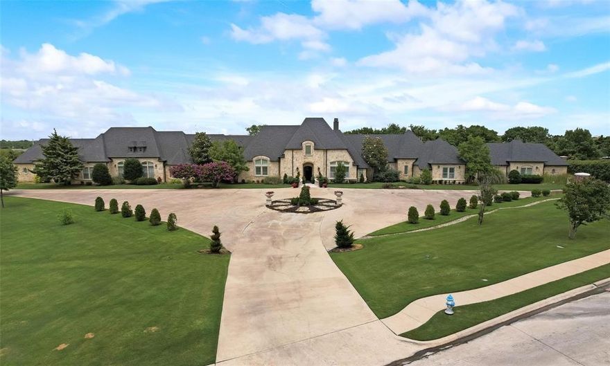 Extraordinary Heath estate offering over 9,200 square feet of refined living, where luxury, lifestyle, and value come together seamlessly. Situated on a 2.86-acre homesite, the property showcases impressive curb appeal with a circular drive, private motor court, and tranquil neighboring pond views, creating both privacy and a grand first impression. This meticulously updated 1.5-story residence features high-end finishes and exceptional craftsmanship throughout. The gourmet kitchen is designed for both daily living and entertaining, complete with commercial-grade appliances and expansive prep and gathering space. The home offers four bedrooms, including two expansive primary suites, each with a private sitting area and spa-inspired en-suite bath, ideal for multi-generational living or extended guests. Upstairs, a one-of-a-kind Disney Castle–themed great room provides a versatile space for recreation, study, or relaxation, adding a unique and memorable element to the home. The outdoor living experience is truly resort-inspired, featuring a semi-covered pool and spa, multiple entertaining areas, outdoor kitchen, fire features, sand volleyball court, in-ground trampoline, zip line, and disc golf. Dual gated entries lead to separate garage wings, including a 4-car garage plus an additional 2-car garage currently utilized as a 640 sq ft climate-controlled recreation space, offering flexibility for a gym, studio, or additional living area. Please ask about the Features List for a complete overview of this exceptional property.