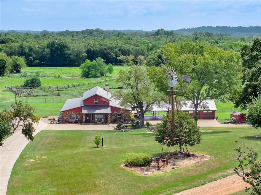 Winnsboro, Wood County Texas – Premier 378± Acre Ranch with 2 Residences & Exceptional Improvements. Discover this rare large acreage tract featuring rolling pastures, fertile bottomland, a seasonal creek, multiple ponds, & abundant wildlife. With prime road frontage on both SH 37 & FM 312, this property offers excellent accessibility while maintaining the privacy &charm of a true country retreat. Main Residence: The centerpiece of the property is a 4BR-2.5BA lodge-style home with approx. 2,700 SF of living space. Highlights include: Expansive open concept kitchen, dining, & living areas with soaring ceilings & custom wood finishes. Gourmet kitchen with large island, abundant counter space, dining bar, & walk-in pantry with built-in cabinetry. Massive living room with 19’ vaulted ceilings, stone wood-burning fireplace, & exposed log trusses. Primary suite featuring 9’ ceilings, a spa-style bath with dual vanities, custom tile walk-in shower, & oversized walk-in closet with built-ins. Additional living space, including a downstairs game room, ideal as a flexible 5th bedroom, & upstairs guest bedroom. Outdoor: Step outside to a private covered 49x15 entertainment deck with outdoor kitchen, propane cooking setup, ceiling &wall fans, + an extended deck with hot tub. The property is fully equipped for country living with 73x50 insulated shop with concrete floors, tack room, & adaptable livestock or horse facilities. RV pad with hookups, well house, backup generator, cattle working pens, chicken coop, storage buildings, & plant room. Second Home across the dam of the property’s scenic lake lies a 2006 built 3BR-1BA with 1200 SF perfect for extended family or guests. A covered 320 SF front porch with panoramic views, attached 528 SF carport with storage. Land & Wildlife: Rich mix of pasture, creek-front areas, & bottomland create excellent opportunities for livestock, hunting, or recreation. Wildlife is plentiful, & the land offers practical agricultural productivity.