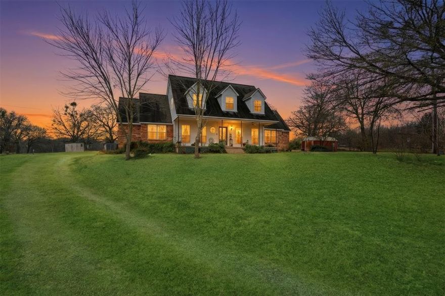 Nestled on beautiful acreage in the peaceful countryside of Caddo Mills, this unique property offers a rare opportunity to own two fully functional homes in a serene, private setting. Mature trees frame the landscape, while a picturesque pond at the front of the property creates a welcoming first impression. Expansive back pastures attract abundant deer and wildlife, delivering a true Texas country lifestyle. The main residence is warm and inviting, featuring a charming covered front porch and classic exterior details. Inside, soaring vaulted ceilings with exposed wood beams and a tongue-and-groove wood ceiling create an impressive great room filled with natural light. A stunning stone fireplace anchors the living space, flanked by built-in shelving that adds both character and functionality. The open-concept layout is ideal for entertaining, seamlessly connecting the living, dining, and kitchen spaces. The kitchen offers generous cabinetry, ample counter space, built-in appliances, and views of the surrounding property. Additional living spaces include an upstairs overlook and secondary rooms with charming architectural details, offering flexibility for bedrooms, home offices, or hobby spaces. Both homes are thoughtfully set back from the road, ensuring privacy and a quiet, peaceful atmosphere. Located in the desirable Caddo Mills ISD, this property provides the perfect balance of rural tranquility and everyday convenience—just a short drive to shopping, dining, and amenities in Greenville and Royse City. Whether you’re seeking multi-generational living, guest accommodations, or simply room to roam, this exceptional property offers endless possibilities in a setting that’s hard to find. Schedule your showing today!