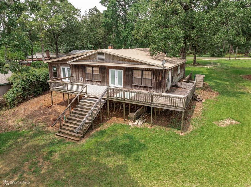 LAKE BISTINEAU HOME  
This partially remodeled home on beautiful Lake Bistineau is full of potential! Whether you're looking for a relaxing fishing camp, a full-time family home, or a fixer-upper investment property, this one fits the bill. Enjoy lake access via a narrow channel. The expansive back porch is perfect for relaxing, entertaining, or soaking in the serene natural surroundings.
The home includes a comfortable living area plus 735 sq ft of unfinished space, ideal for expanding with a master suite, guest bedrooms, or a custom retreat.
BONUS: A .78-acre lot directly across the street is also available for purchase (not included in list price). It comes equipped with electricity, a water well, and a sewer system—a perfect setup for an RV, mobile home, or workshop.  Please call for more information.