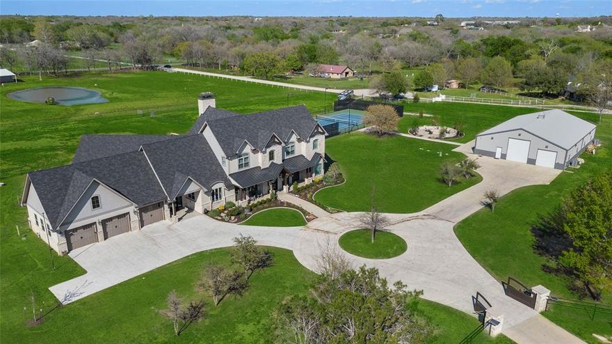 Welcome to 341 Springfield Bend, Argyle, TX - where luxury meets tranquility! This custom-built masterpiece, constructed in 2019, boasts commercial-grade finishes and a contemporary yet charming Modern Farmhouse aesthetic that will leave you breathless. With 5 bedrooms, 4 full bathrooms, and 2 half baths, this home offers an abundance of space for both relaxation and entertainment. The layout is designed with the majority of the living space on the first floor. Prepare to be amazed by the 80 x 50 HVAC Man-Cave, a haven for any enthusiast, with glass doors leading out to the fire grotto and tennis courts. Whether you're hosting lavish gatherings or enjoying quiet evenings, this outdoor space offers endless possibilities for all. Nestled on over 5 acres of picturesque land.