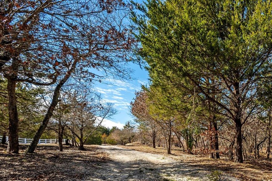 11 ACRES on PRIVATE FLAG LOT with so many possibilities- UNIQUE opportunity! MAKE this PROPERTY your OWN on UNICORPORATED LAND! CURRENTLY used for private residence on ONE ACRE surrounded by underdeveloped TEN WOODED ACRES with CREEK, BRIDGE, 2 TREEHOUSES and a WELL! This RUSTIC home has TWO PRIMARY bedrooms - one UPSTAIRS with SITTING AREA and upstairs LOFT, second PRIMARY bedroom DOWNSTAIRS, HUGE FAMILY, updated KITCHEN with ISLAND, BRIGHT dining area and SEPERATE DETACHED STUDIO with HVAC that could be used as an office or gameroom! OVER 1400 square foot COVERED PATIO with STONE FIREPLACE, several SITTING AREAS and FUN LIGHTING - AMAZING area for ENTERTAINING!! OVERSIZED GARAGE with 575 square feet. COUNTRY LIVING with CITY ACCESS in PRIME LOCATION just minutes from downtown Mckinney SQUARE and highway 121!