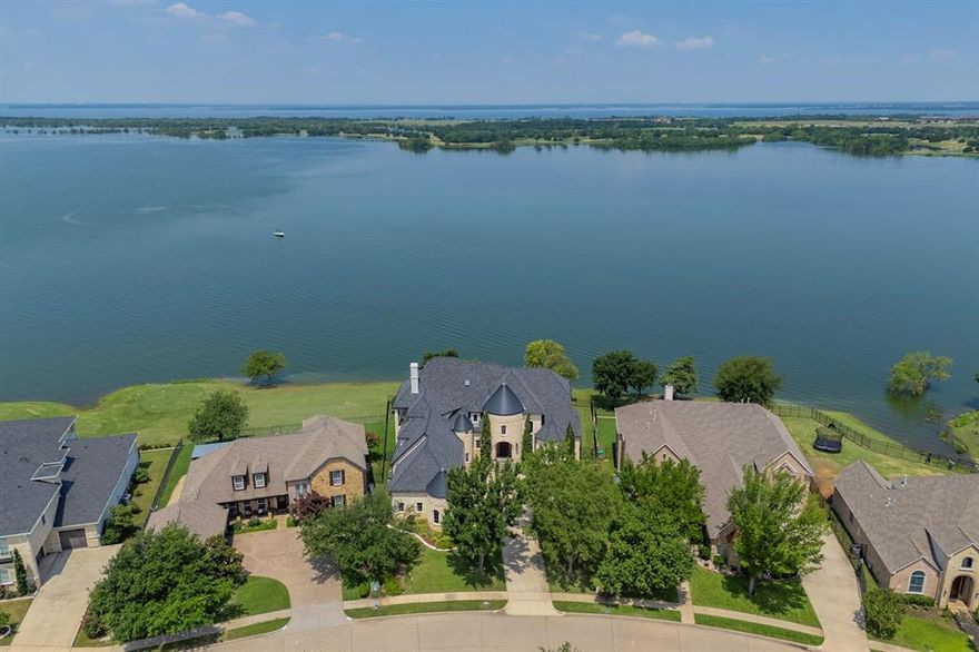 *Multiple offers received! Deadline: Tuesday May 27th at 12 pm *

The Castle House is an exquisite property! With amazing curb appeal and Old World charm, this exceptional 7,363SF lakefront home features three stories of outstanding views and amenities with plenty of architectural interest.

From the copper patina gutters, the gas lamps and metal topped turrets, to the austin stone exterior with slate accents, raised flower beds and fountain, this highly custom home is a stand out!

This artist’s home was lovingly designed by these original owners. One of a kind features abound such as the floating staircase which is an engineering marvel. The porcelain sinks were hand painted by the owner and then kiln fired. You won’t find any others like them! The granite is Russian Blue Vulga, the same granite featured in the Cowboy Stadium. Jerry Jones loved it so much he purchased the mine!

The owners were the first to purchase on Westway and chose this particular lot as they felt it was the best. You will agree when you see the sweeping lake views from nearly every window, when you enjoy the massive wrap around balconies and covered patios, while you’re lounging around the pool watching watercraft whizz by and as you’re enjoying the easy access down to the lake.

22’ ceilings greet you in the grand entrance and the peace of the water views will begin to work their magic from the moment you step inside. The main living area is welcoming and warm, Huge bay windows open onto stellar lake views & the ninth Tee box. 

The master suite was built to pamper. Rinse the day off together with double showers or luxuriate in the cast iron claw foot tub. Prepare your morning beverage at the coffee bar in the hallway just outside the master, then enjoy a peaceful moment on the balcony.

Of course the kitchen, game room, media room & pool area areas are stand outs, too. This is
just scratching the surface of what can be yours at 6521 Westway. Welcome home!