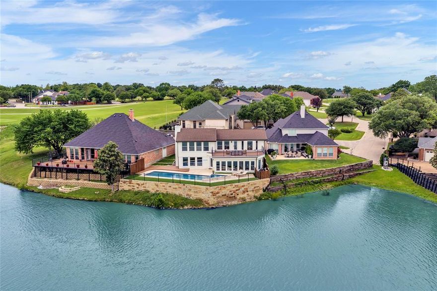 There isn't another one like it. Set above the 18th green of the Hogan Course at Trophy Club Country Club, 9 Avenue Twenty is the rare offering where golf course prestige and lakefront ambiance converge, and where every detail inside matches the drama of the views outside.

Walls of windows frame Trophy Club Lake and the golf course from nearly every room. A generous second-story deck becomes a third living room. Below, a redesigned lap pool and spa create the place to be all summer long. The setting is effortless. The views, unforgettable.
Inside, the home has been completely reimagined and it goes beyond expectations. The layout flows with intention. Smooth walls, seamless flooring, and thoughtful details like a wood accent wall and sculptural tile create interiors that feel both elevated and livable. The reimagined kitchen is striking and timeless, with quartz counters and a deep navy backsplash that opens into living spaces designed for refined entertaining or a slow Sunday morning with the fairways as your backdrop. A versatile flex space, equally suited as an office, sitting room, or whatever the moment calls for, adds another layer of livability to an already thoughtfully designed home.

The primary suite is a retreat in the truest sense. A wood-burning fireplace anchors the room while the spa bath delivers a soaking tub, LED rain shower, heated floors, a custom wardrobe that feels tailored to the space, and a Bluetooth-enabled fixture that controls temperature, humidity, lighting, and music

Located minutes from DFW, Southlake Town Square, and both Dallas and Fort Worth, Trophy Club is one of the metroplex's most enduring golf communities. Life is better on the fairway.