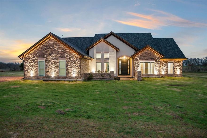Discover your own private retreat on over 4 acres of scenic countryside. This stunning 4-bedroom, 3-bathroom custom rock home is designed to impress, offering panoramic sunset views to the west through expansive windows that bathe the living spaces in natural light. Step inside to find a warm, inviting atmosphere highlighted by stone-accented fireplaces in both the living room and primary suite. Built with commercial-grade materials and meticulous craftsmanship, this home blends quality, comfort, and durability at every turn. A generously sized bonus room provides flexible space perfect for a home gym, media room, or creative studio. Outside, enjoy the freedom and tranquility of wide-open spaces—ideal for outdoor recreation, gardening, or simply soaking in the serene surroundings.