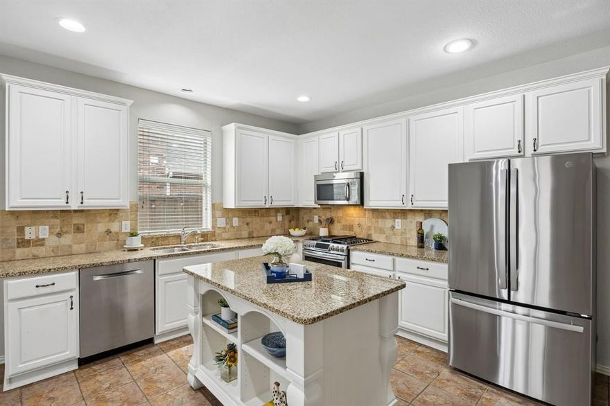 Nestled in highly sought-after Grayhawk in West Frisco, this thoughtfully updated home offers the perfect blend of comfort, style, & everyday functionality. Ideal for any buyer looking to simplify without sacrificing space, the flexible layout lives beautifully.  Step inside to warm hand-scraped hardwoods in the front living area & engineered wood flooring throughout the bedrooms, creating a cohesive & inviting feel. A dedicated study with double doors offers the perfect work-from-home space, plus an additional flex room with unlimited possibilities. The updated kitchen perfect for everyday living & hosting, featuring granite countertops, stylish cabinet hardware, a double convection oven, and a 5-burner gas range. A functional island with drawer storage and open shelving adds both practicality and personality. The kitchen flows seamlessly into the expansive family room and dining area, creating one large gathering space ideal for family time or entertaining friends. The secondary bath features updated shower tile, vanity, mirror, lighting, granite counters, and fixtures. In the primary suite, enjoy a fully updated separate shower with designer tile and glass surround, along with a double vanity topped with granite and updated lighting and fixtures. The primary bedroom is privately tucked away from the secondary bedrooms. Behind the scenes, valuable updates include a new water heater (2024), freshly stained fence, and a new garage door opener. Step outside to a backyard designed for easy living and fun. The covered pergola and extended patio create the perfect outdoor retreat, while the maintenance-free turf means no mowing. A fun bonus feature is the private putting green along the side of the home, perfect for practicing your short game or enjoying a relaxing evening outside. Located in an amenity-rich community with multiple pools & playgrounds, & just minutes from the DNT, shopping, & dining, this home offers a lifestyle of convenience & connection.