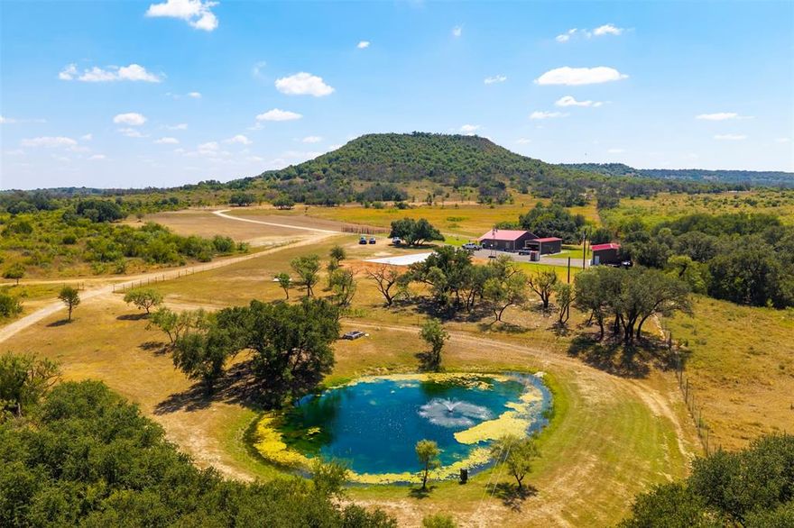 Rockin’ S Ranch is a premier, high-fenced turn-key property just minutes from Comanche, Texas. Set on 235 acres of beautiful, well-watered land and stocked with 14+ species of trophy exotics, this ranch blends luxury living with exceptional recreation. Rockin’ S Ranch is ready for a new owner to step in and immediately enjoy the ultimate Texas ranch lifestyle. The ranch features a luxurious 1,932+ sqft, 3-bedroom 2-bath home. Outdoor spaces include a pavilion, barns, and multiple blinds and feeders. A brand-new 100x30 party barn is under construction and will serve as a versatile multi-use space for future owners. This combination of existing comfort and new development creates a turn-key setup with plenty of room to grow. Animals include Waterbuck, Sable, Ibex, Nyala, Oryx, Elk, Buffalo, Kudu, Axis, Markhor, Wildebeest, Blackbuck, Aoudad, and Whitetail with enhanced genetics, along with Rio Grande Turkey and other native game. Equipment included is a 2025 John Deere 520M tractor with a cab and a full set of attachments: 12ft brush hog, 6ft brush hog, 8ft disc, 12ft disc, 2 box blades, root plow, seed planter, bucket, and hay forks. Also included are a 2025 Kubota 75-3 skid steer with a cab, bucket, and drum mulcher, a 2025 Polaris Ranger 1500, a 2023 Can-Am Defender, two zero-turn mowers (2025 John Deere & 2020 Bad Boy), and a 16ft pipe-top trailer with brakes. Multiple protein and corn feeders, along with blinds, are also part of the package, making this a truly turn-key ranch. Water resources on the property are abundant and thoughtfully improved. There are four wells, including a brand-new solar ag well that supplies irrigation and supports the ranch’s water features. In total, there are three ponds, one at an acre in size and two at ¼ acre each, two of which are stocked. A heavily wooded wet weather creek also runs through the property, and two new 2,500-gallon storage tanks provide additional water capacity for irrigation.