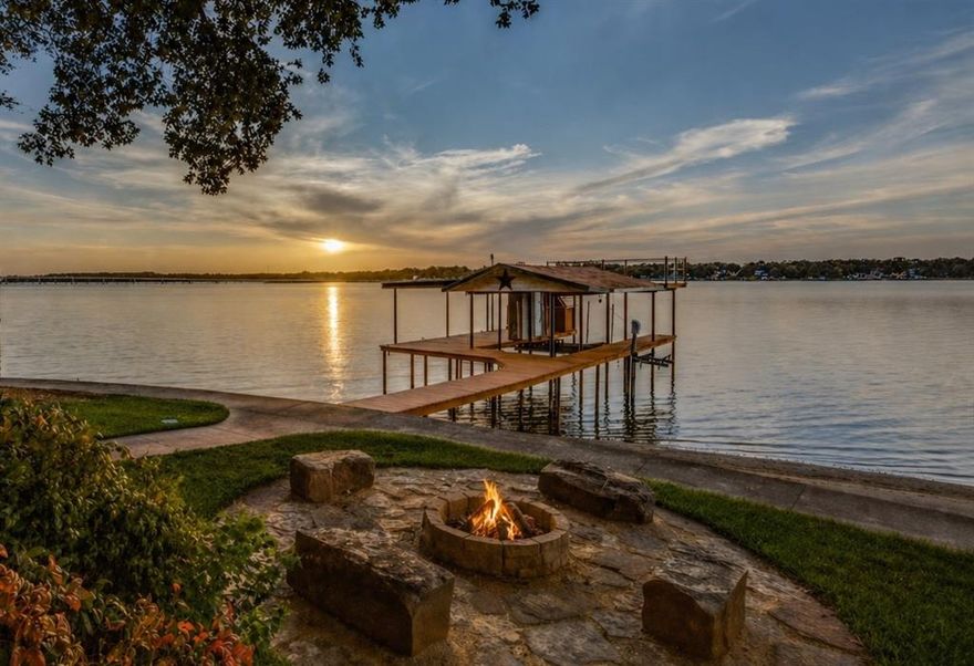 Set on a beautifully treed, fully fenced waterfront lot with open water views, this charming lake cottage offers a wonderful blend of outdoor living space and privacy. An elevated covered deck overlooks the spacious yard, waterside stone fire pit, and well-maintained boathouse with party deck seating, creating an inviting setting designed for enjoying life at the lake. An expansive driveway provides plenty of parking for guests, complemented by a detached two-car garage, a two-car carport currently functioning as a covered sitting area ideal for grilling and gathering, and two additional storage sheds for lake toys and lawn equipment.

Inside, a spacious waterside sunroom serves as both dining and additional living space, bringing natural light and lake views while flowing seamlessly into the open-concept living and kitchen area. The home offers approximately 1,320 square feet with vaulted ceilings, fresh interior paint, durable LVP flooring, and a fireplace with gas logs anchoring the main living space. Two spacious bedrooms and two full baths feature granite countertop vanities, including one with a walk-in shower and the other with a tub-shower combination.

The boathouse is equipped with a pontoon cradle, PWC lift, and lake pump sprinkler system, while the detached garage is plumbed for a bath, offering future guest quarters potential. Also offering added versatility, the property is an established top-rated short-term rental with excellent guest reviews, making it well suited as either a personal lake retreat or investment opportunity.