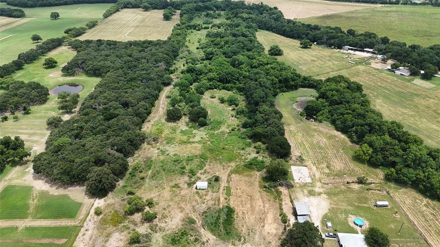 Seclusion with easy access to I35! 28ish acres pending final survey.  150' of frontage on FM 916 that opens up in the back that will include pole barn large rectangle shape acreage, stock tank and fully fenced.  Lots of large trees as well as open pasture area where current owners cut hay.  Call today to make an appoint to view the back of this amazing property! No coop water available, buyer will need to dig well.