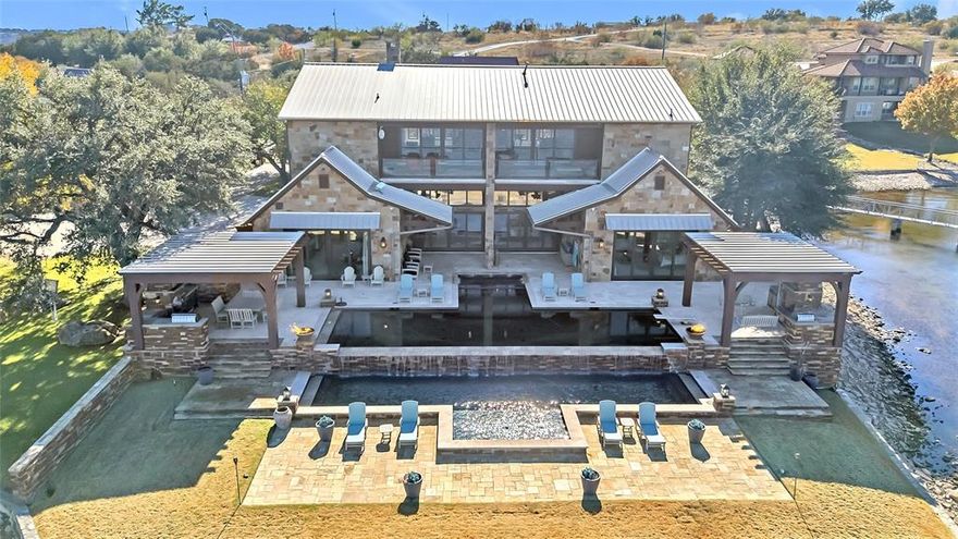 Experience Unparalleled Luxury Living at PK Lake! 
Nestled on a private gated point with breathtaking panoramic views of dramatic cliff walls, this architectural masterpiece will captivate you from the moment you enter. Boasting 5 bedrooms, 5 full baths, and 2 half baths, this newly renovated estate combines sophisticated design with resort-style amenities for the ultimate lakefront lifestyle. 
Step into a spacious open-concept living, dining, and gourmet kitchen featuring a Wolf range, multiple dishwashers, dual ice machines, and a separate wine cellar that also serves as a coffee bar. This elegant and functional layout is ideal for hosting and entertaining, with expansive walls of glass showcasing the views and providing seamless access to the outdoor living areas. Enjoy a multi-level heated pool and spa, along with outdoor kitchen pavilions designed for effortless entertaining.
The private dock offers effortless access to a serene cove, perfect for boating and water sports. Inside, discover dual master suites, one transformed into a custom bunk room, teen lounge, and fitness studio with steam shower, a mother-in-law suite and two additional
bedrooms en suites.
The upper level is an entertainer’s dream, featuring a designer bar and gaming lounge with pool table, poker tables, and shuffleboard, opening to a panoramic-view terrace. For movie nights, retreat to the state-of-the-art stadium theater with eight oversized
recliners for a true cinematic experience.
This home is more than a property—it’s a luxury lifestyle destination. With too many features to list, this is your chance to own one of PK Lake’s most exclusive waterfront estates.