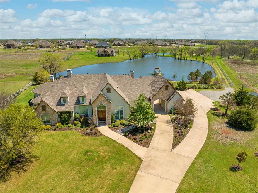 Live your very own version of the Yellowstone lifestyle in Lucas, TX!  This sprawling and elegant custom home was designed with Texas style living and entertaining in mind. Situated on 13.81 acres with a private Florida-bass stocked lake, parking for up to 10 vehicles and RV and an incredible 4,000 square foot stable with 1,600 second floor for potential living quarters. The main house is graced by three stone front fireplaces and plenty of room for entertaining with formals, central living space and oversized family room.  Master suite has recently updated bath with gorgeous soaking tub and walk-through double shower. Beautifully open kitchen is centered at the heart of the open floorplan and nearby coffee bar features KitchenAid pellet icemaker. Horses are allowed and the entire property is enclosed with pipe rail fencing. Enjoy the beautiful sunrise over your own lake in the nature lover's dream.