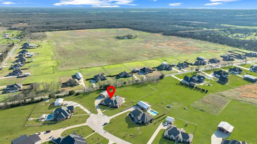 Nearly 2 acres, resort-style pool, outdoor living pavilion, and a 1,200 sq ft shop—this Caddo Mills property offers the perfect blend of luxury, space, and freedom with no HOA and lower taxes. Nestled in the charming community of Caddo Mills, this beautifully designed home provides the privacy of country living while remaining conveniently connected to town amenities. With over 2,800 square feet of thoughtfully designed living space, the home balances comfort, style, and functionality.

Inside, rich hand-scraped hardwood floors create a warm and inviting atmosphere. The spacious floor plan features 3 bedrooms, 2.5 baths, two dedicated office spaces, and two dining areas—perfectly suited for today’s flexible lifestyle of working, gathering, and entertaining.

The primary suite is a true private retreat, highlighted by a generous walk-in closet and an adjoining bonus room—ideal for a nursery, private sitting area, second office, or media lounge.

Outdoors is where this property truly shines. A newly built pavilion creates the ultimate entertaining space with a cozy fireplace, built-in grill, refrigerator, and automatic electronic roll-down shades for year-round enjoyment. Just beyond, a sparkling pool and relaxing spa complete the private backyard oasis.

The impressive 1,200-square-foot shop is equipped with multiple voltage options for equipment and projects, plus a convenient toilet area—perfect for hobbies, storage, or workspace.

Located within highly regarded Caddo Mills ISD, an exemplary district known for strong academics, this property offers a rare combination of space, luxury, and lifestyle.

Homes with this level of land, outdoor living, and versatility rarely come available—schedule your private showing today.