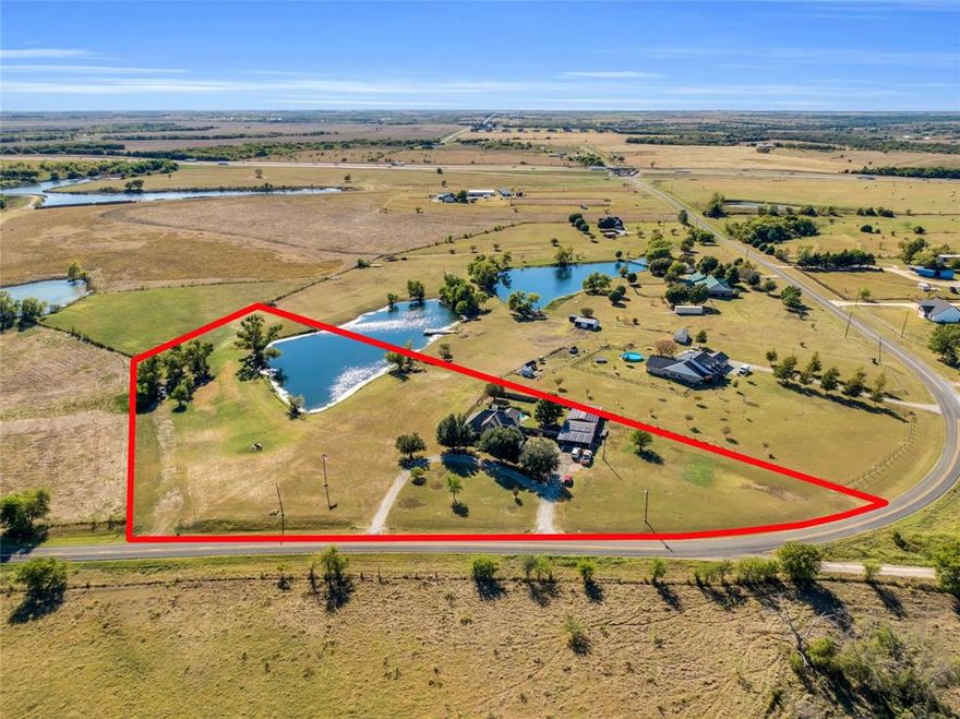Peaceful country living in Grandview, Texas on 5 acres with a beautiful stocked pond for fishing, the perfect place to enjoy the sunrise and sunsets. Located less than half a mile from I-35, this 4-bedroom, 2.5-bathroom home with 2-car garage was built in 2000 offers 2,892 square feet with an open concept layout. The living room features high ceilings and a wood burning fireplace, perfect for cozy evenings. The kitchen showcases granite countertops and flows into the breakfast area with views overlooking the backyard and pool. The primary bedroom and bath include walk-in closets for ample storage, dual sinks, a garden tub, and a large walk-in shower. Located in the Itasca School District, this property has been well-maintained with significant recent updates. The roof was replaced in November 2024, and the home features solar panels for savings on electricity costs. Central air and heat is 8 years old, and the exterior was freshly painted approximately 3 years ago. A sprinkler system surrounds the entire house and yard for easy lawn maintenance. Outside amenities include a refreshing in-ground pool with a large workshop equipped with electricity, 3 roll up doors, and a covered overhang. This property offers room to roam with practical outbuildings and recreational features for the whole family to enjoy!