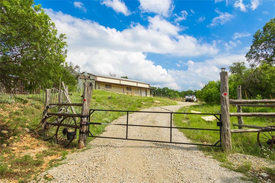 Tucked away in the peaceful countryside, this 2020 custom-built barndominium blends rustic charm with modern comfort. With approximately 1,845 sq ft of living space, this two-story home was built to last with metal purlins, 2” foam, and 6” insulation for durability and energy efficiency. Enjoy quiet mornings on the full-length covered front porch or relax on the deck balcony overlooking a beautiful shared pond—perfect for fishing or watching the sunset over the water.

Inside, every detail has been thoughtfully designed. Downstairs features acid-washed, varnished concrete floors, while the upstairs showcases oak flooring and Colorado Pine baseboards. The home offers 3 bedrooms (or 2 bedrooms plus a man cave with interior half-log walls) and custom craftsmanship throughout. Solid wood cabinets made of red cedar and oak, pecan décor accents, and hand-finished metalwork by Darrin St. Ama add unique character and warmth to the space.

The kitchen is a cook’s dream with a Chef’s Kutch gas stove and oven, stainless farmhouse sink, island, and built-in appliances including a dishwasher and microwave. Refrigerator, washer, and dryer convey. Bathrooms include a clawfoot tub in one and a walk-in shower in the other.

Outside, the property includes an oversized one-car garage, seamless gutters, a 250-gallon propane tank, RV hookups, and a 20-foot shipping container for storage. The 8-acre setting offers open space, trees, and plenty of room to roam, with an inviting deck for outdoor entertaining. Whether you’re looking for a peaceful full-time home or a weekend retreat, this barndominium provides the perfect blend of craftsmanship, comfort, and Central Texas country living.
