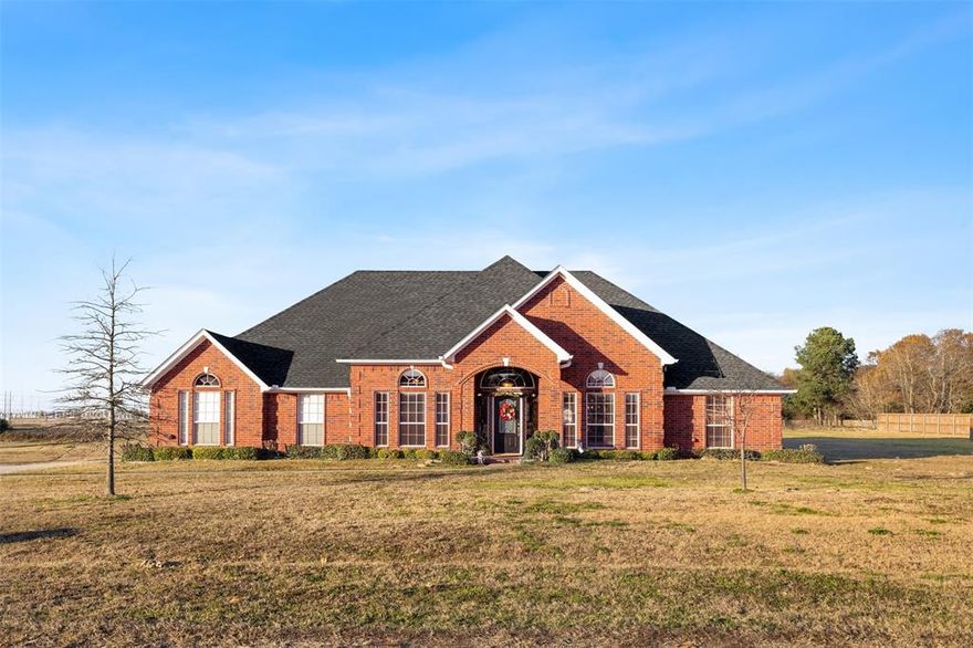 This custom brick home sits on a 1.15-acre corner lot and offers 4 bedrooms, 3 full bathrooms, and 1 half bath with a spacious, functional layout. The open-concept living area features a brick fireplace, built-in bookshelves, and a wall of windows that brings in abundant natural light. The kitchen includes an electric oven, tile backsplash, breakfast bar, and easy access to the breakfast nook. A two-car garage provides convenient parking and storage, and the expansive lot offers plenty of room to enjoy outdoor living.