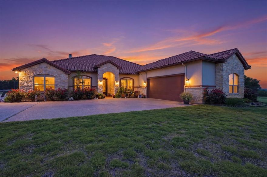 Set on 10 picturesque acres, this stunning estate offers the perfect blend of refined comfort, functionality, and wide-open Texas living. Upon arrival, the beautiful perennials and warm architectural details create a lasting first impression. The land is dotted with beautiful oak trees, a seasonal pond, and a large stone fire pit. Inside, the home welcomes you with an open-concept design, abundant natural light, and elegant finishes. The spacious living area features a striking stone fireplace and seamless flow into the kitchen, complete with rich cabinetry, granite countertops, a large island, bar seating, and a dedicated ice maker. The kitchen also offers a walk-in pantry plus a second pantry, providing exceptional storage. The home includes both a formal dining room and a breakfast room with exceptional views. The primary suite is a serene retreat, showcasing a tray ceiling, generous natural light, and a spa-like ambiance. The en suite bath features dual walk-in closets, with the largest doubling as a concrete storm shelter. Throughout the home, plantation shutters and motorized shades provide both style and convenience. Step outside to your own backyard oasis, where a covered patio with motorized screens allows for year-round enjoyment. The sparkling pool, lush landscaping, and multiple seating areas create the perfect setting for relaxing or entertaining. From the back porch, enjoy gorgeous sunset views stretching across the surrounding acreage. The home is enhanced with decorative jellyfish-holiday lighting, adding charm and appeal year-round. For those needing additional workspace or storage, the property includes a 24x24 metal building with a concrete floor and a 12x21 greenhouse. A spacious attic provides an abundance of easily accessible storage. With expansive open land, scenic views, and thoughtful upgrades throughout, this exceptional property delivers the ideal balance of luxury, privacy, and country living—just waiting to be called home.