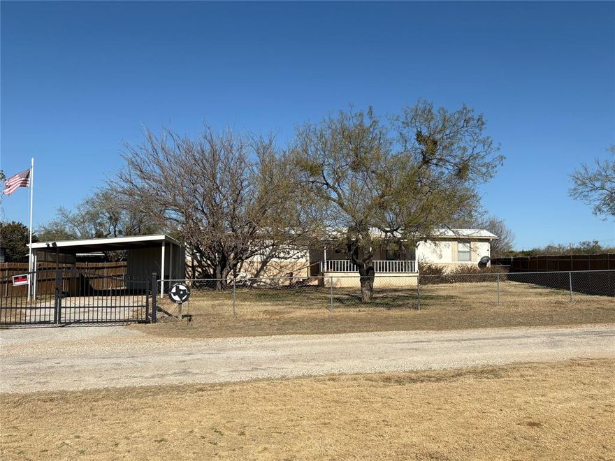 This 2 bed 2 bath home sits on almost .5 acre inside a fenced in yard with a water view right from the covered front porch. Give this place a little love and attention and it will be the perfect place for a weekend getaway or full time living right here on Possum Kingdom Lake. You cannot beat the sunsets you will see here. Some additional features to the property include an underground storm cellar, a 2 car detached carport along with 3 storage buildings or shops and a gated entry to the driveway.