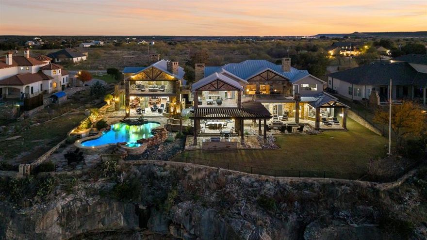 This stunning luxury Possum Kingdom Lake, house spans an impressive 9,415 square feet of meticulously designed living space. Crafted with the finest materials and showcasing breathtaking lakefront views, the residence offers an unparalleled blend of sophistication, comfort, and natural beauty.

The main house features an expansive open-concept layout, with soaring ceilings, floor-to-ceiling windows, and bespoke finishes throughout. The gourmet kitchen, equipped with state-of-the-art appliances and custom cabinetry, flows seamlessly into the elegant dining and living areas, creating a perfect setting for both everyday living and entertaining. A grand fireplace anchors the great room, which opens up to an oversized terrace, ideal for enjoying the tranquil lake views or hosting alfresco gatherings.

The master suite is a private sanctuary, complete with a spa-inspired en-suite bathroom, a custom walk-in closet, and panoramic views of the water. Additional bedrooms are generously sized, each with access to luxurious baths and high-end amenities. A wine cellar add to the property’s appeal, ensuring every need is met with ease.

For guests, the property features a walk through breezeway to a separate, fully appointed guest quarters, offering ultimate privacy and comfort. Whether hosting friends or family, the guest house provides a refined space with its own living area, kitchen, and stunning lake vistas.

Outside, the property is equally remarkable, with expansive patios, and an infinity-edge pool all designed to take full advantage of the serene lakefront location. Lush landscaping and a built-in outdoor kitchen complete the look.

This lake house on Possum Kingdom Lake offers not just a home, but a lifestyle—where modern elegance meets the tranquility of nature, creating the ultimate retreat for those seeking privacy, sophistication, and the beauty of lakeside living. A must see in person. Too many pictures to upload.